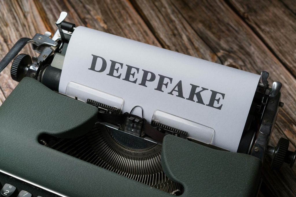 Close-up d'une machine à écrire avec le mot "Deepfake" tapé sur du papier. Concept de technologie et de médias.