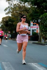 Une femme courant dans un marathon en milieu urbain. Concentrée et déterminée.