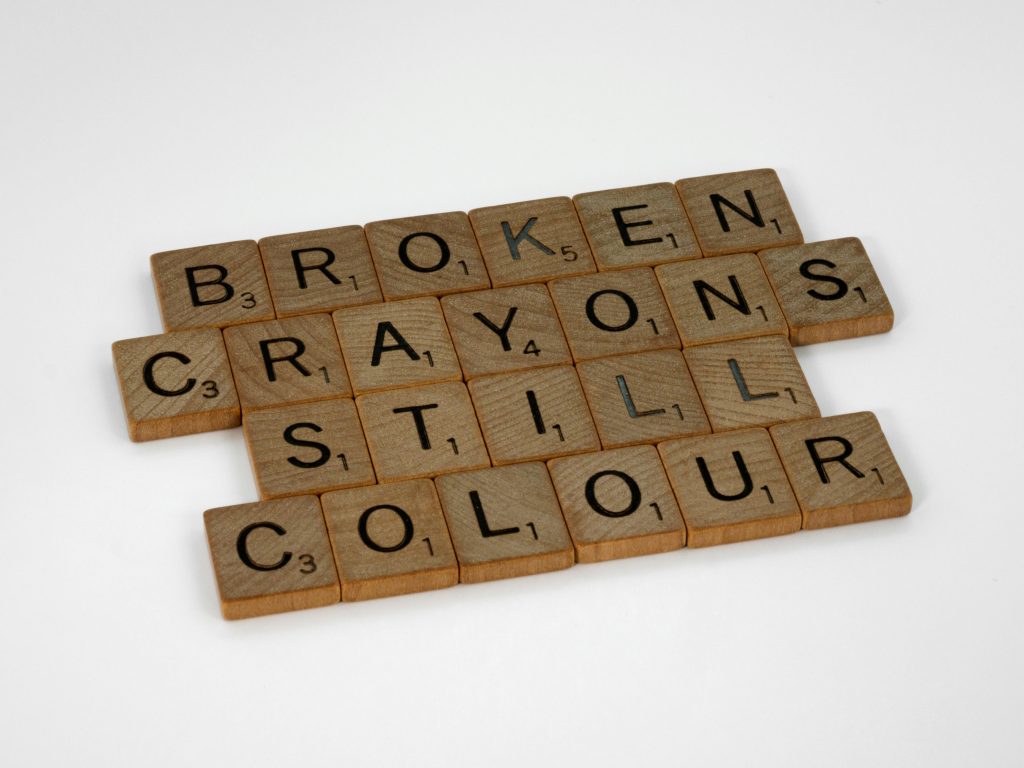 Scrabble tiles spelling 'broken crayons still colour' on a white background. Des tuiles de Scrabble épelant « broken crayons still colour » sur un fond blanc.
