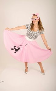 Une femme en jupe à cercles style années 1950, dansant et posant avec une expression joyeuse.