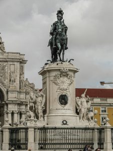 La statue emblématique du roi José I à la place du Commerce à Lisbonne, mettant en valeur des sculptures détaillées.