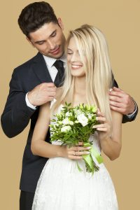 Wedding couple embracing with bouquet, showcasing love and elegance. Un couple de mariés s'embrassant avec un bouquet, mettant en avant l'amour et l'élégance.