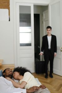 Man discovers unexpected scene in doorway, capturing shock and emotions. L'homme découvre une scène inattendue à la porte, capturant le choc et les émotions.