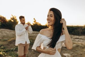 A happy couple in a sunlit meadow, enjoying a warm summer day together. Un couple heureux dans une prairie ensoleillée, profitant ensemble d'une chaude journée d'été.