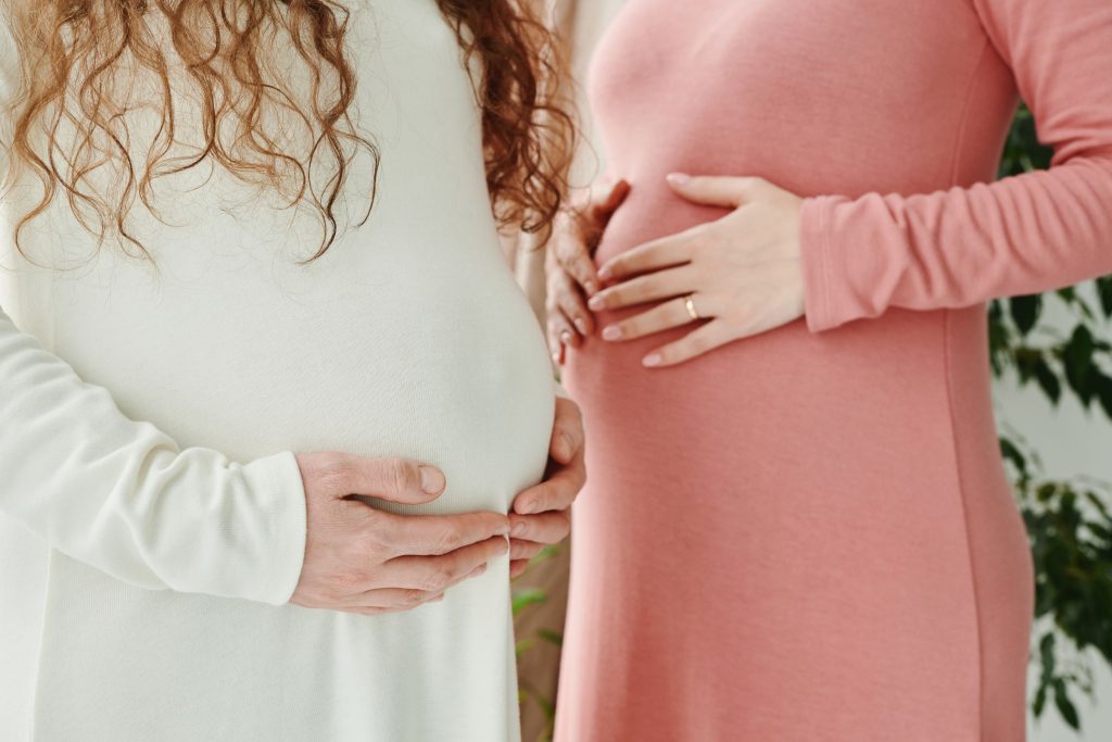 Deux femmes enceintes se tenant le ventre en fin de grossesse