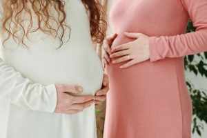 Deux femmes enceintes se tenant le ventre en fin de grossesse