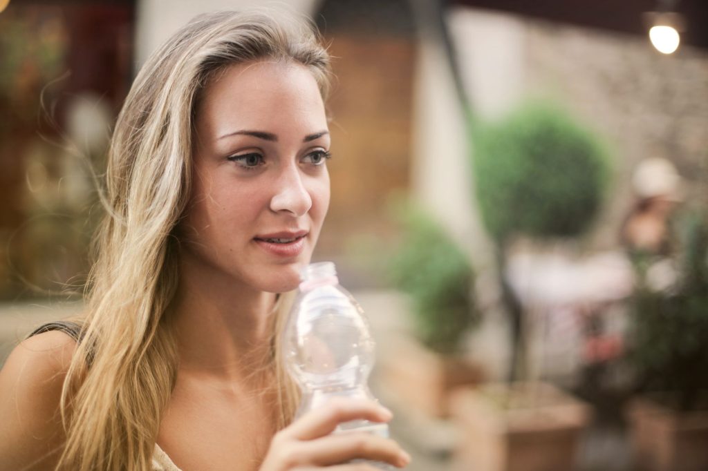 Femme buvant de l'eau en extérieur