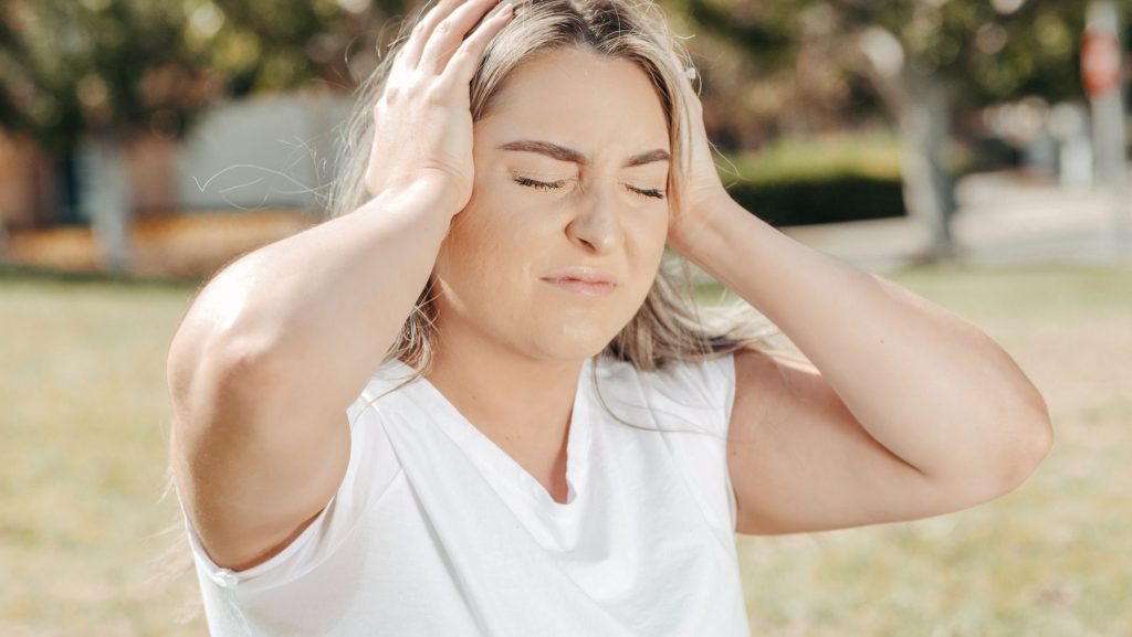 Femme qui se tient l'oreille douloureuse