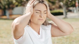 Femme qui se tient l'oreille douloureuse