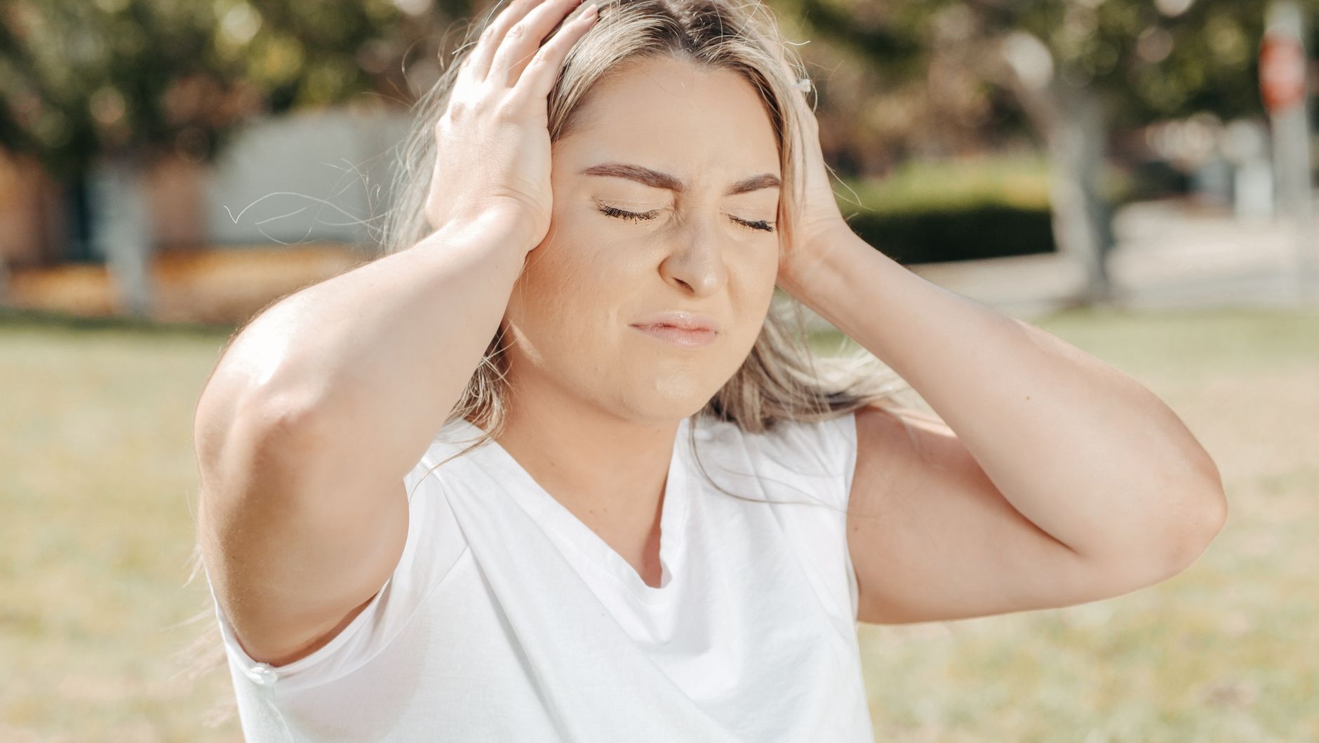 Femme qui se tient l'oreille douloureuse