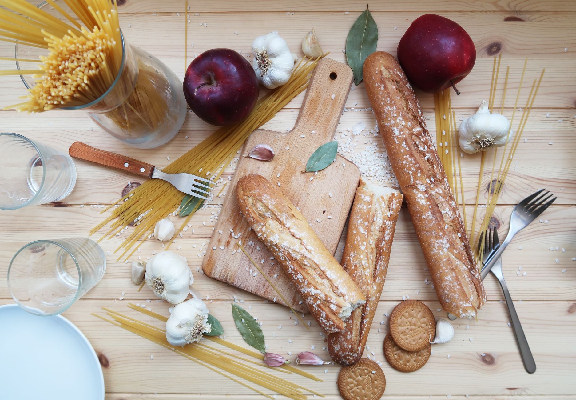 Pain, pâtes et fruits sur une table en bois