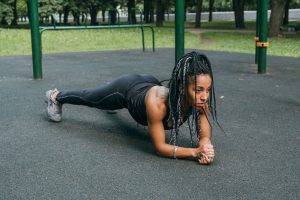 Femme en position de planche dans un parc