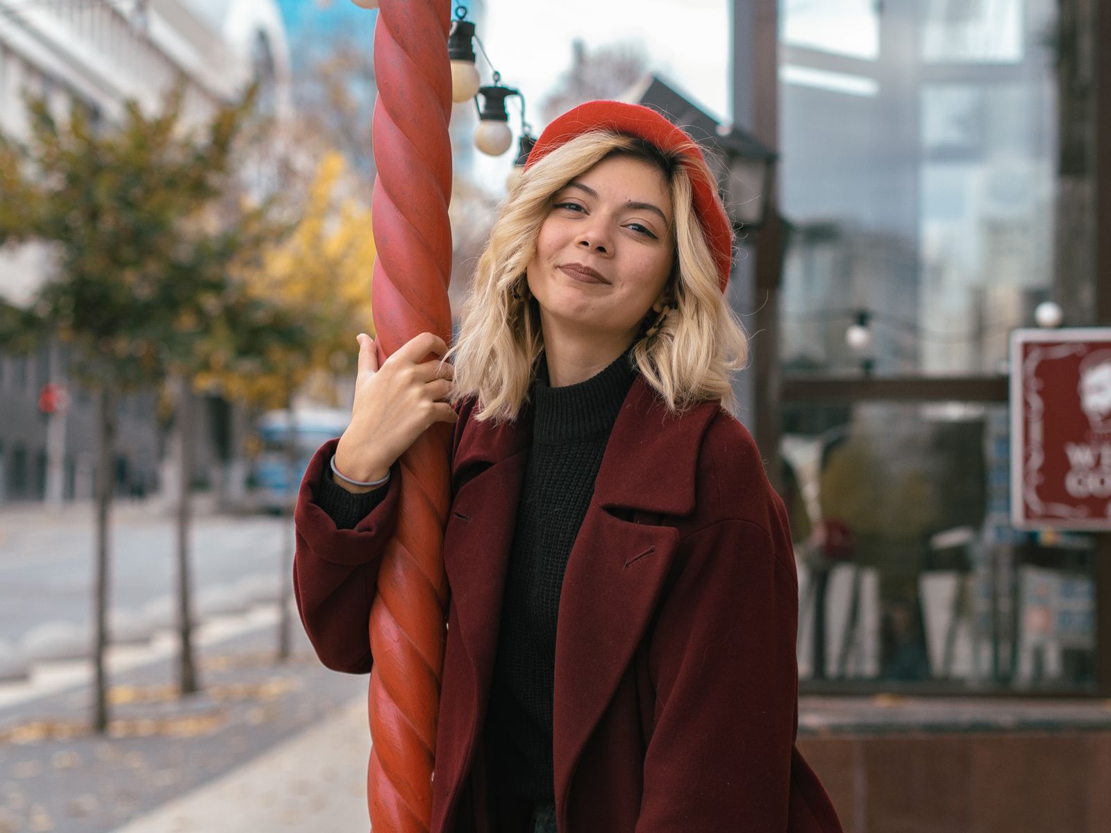 Femme portant un béret rouge et un manteau en ville