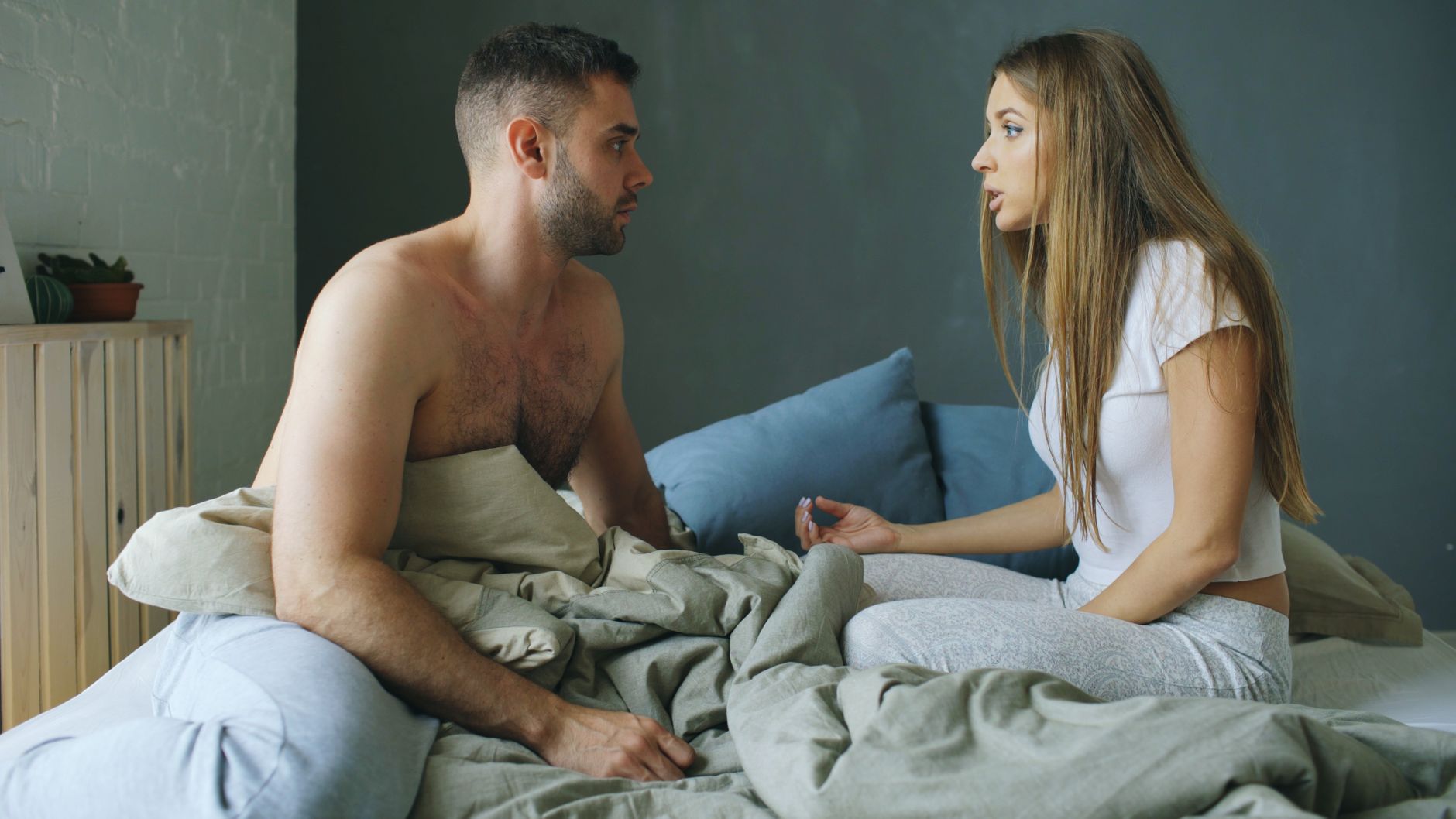 Couple qui discute assis sur le lit