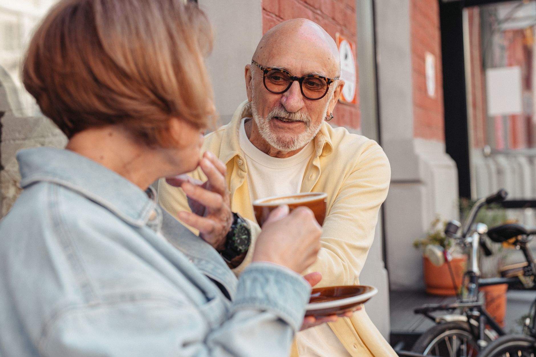 Couple senior partageant un café en terrasse