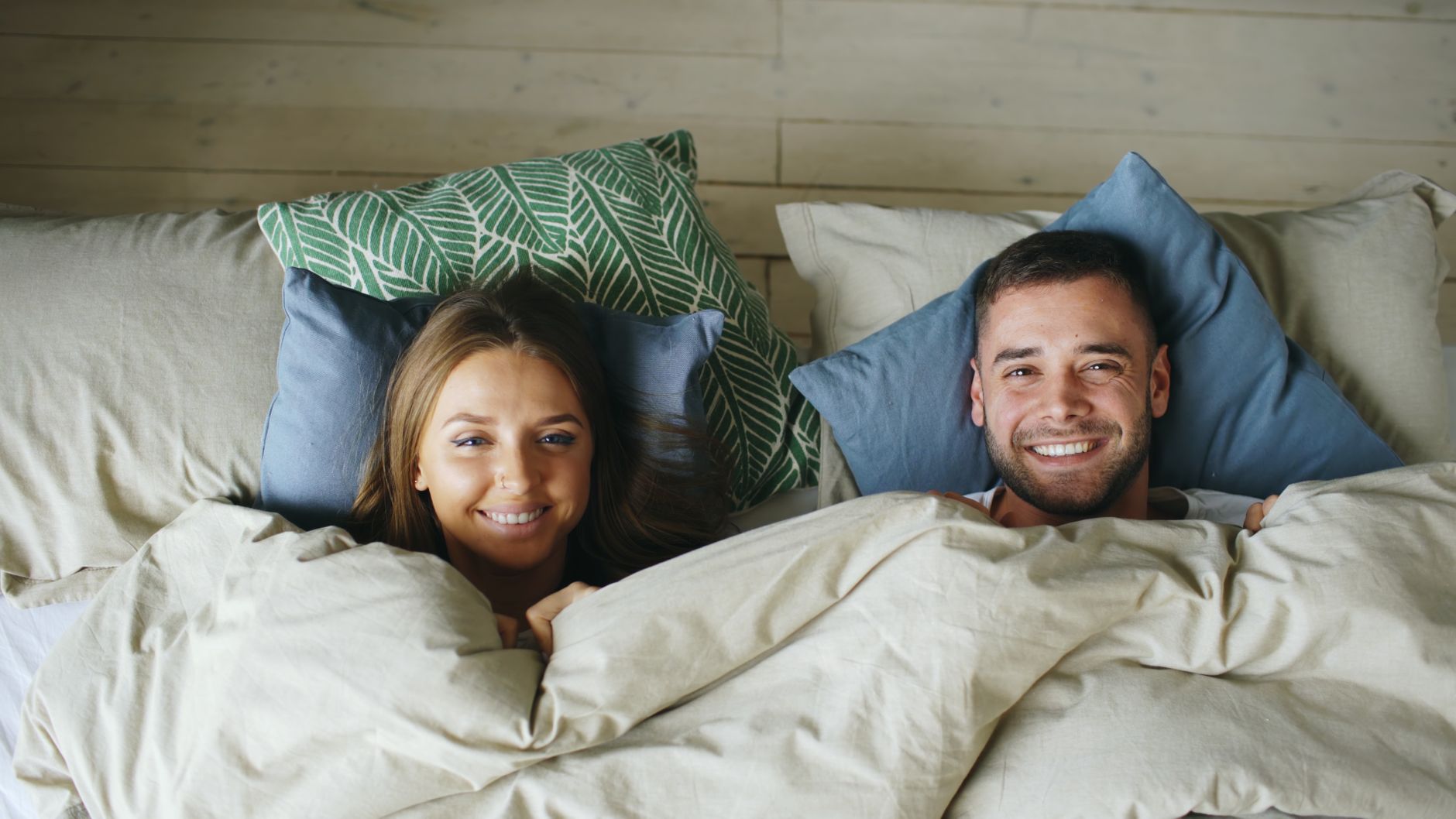 Couple détendu au réveil dans une chambre lumineuse