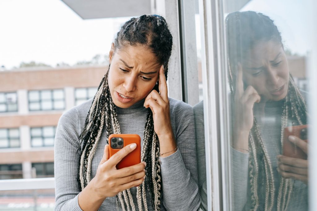 Femme inquiete devant son telephone apres une rupture