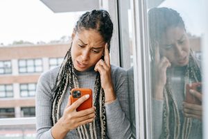 Femme inquiete devant son telephone apres une rupture