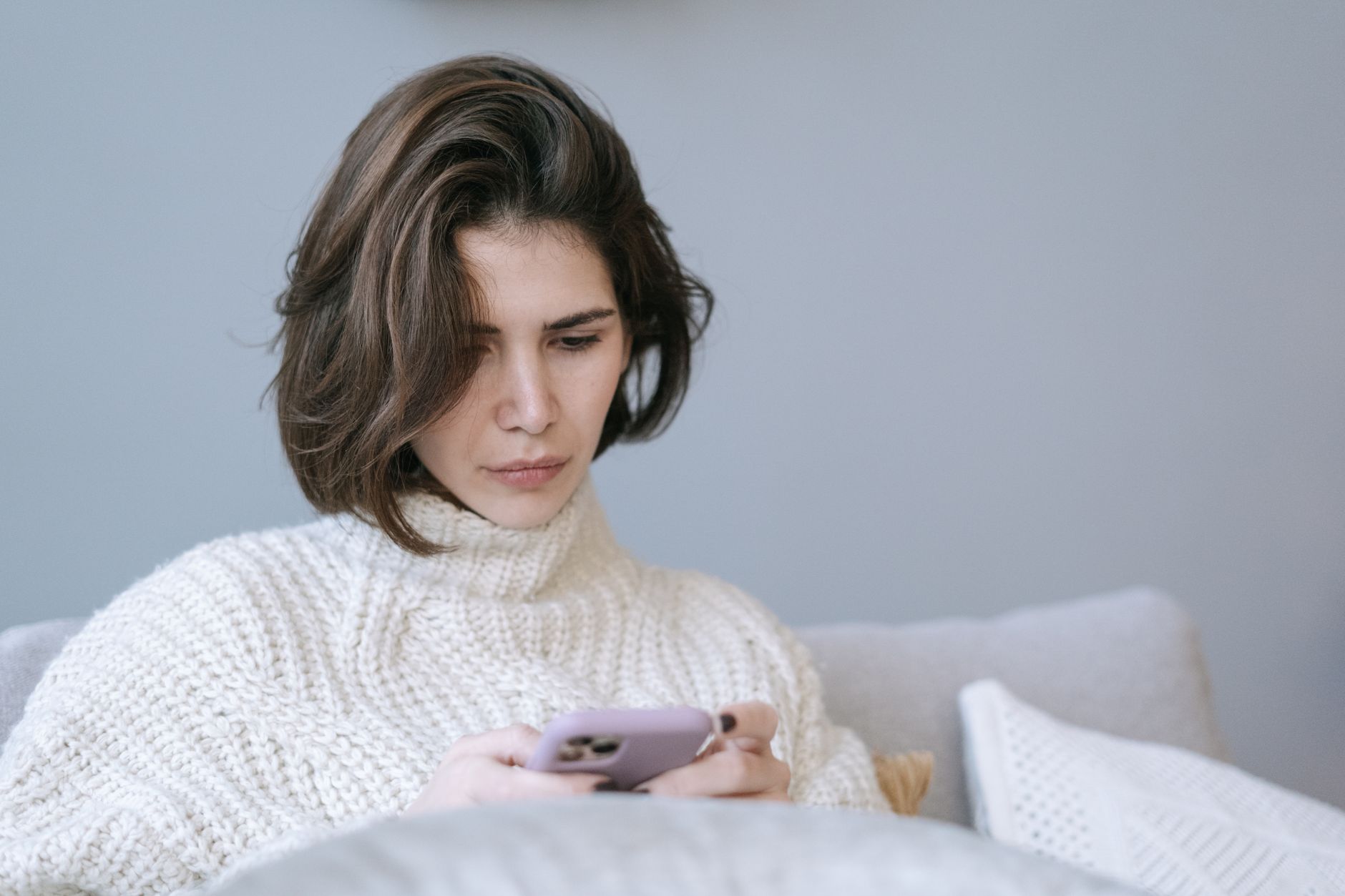 Femme qui regarde son téléphone avec inquiétude