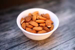 Bol d amandes en céramique sur une table en bois