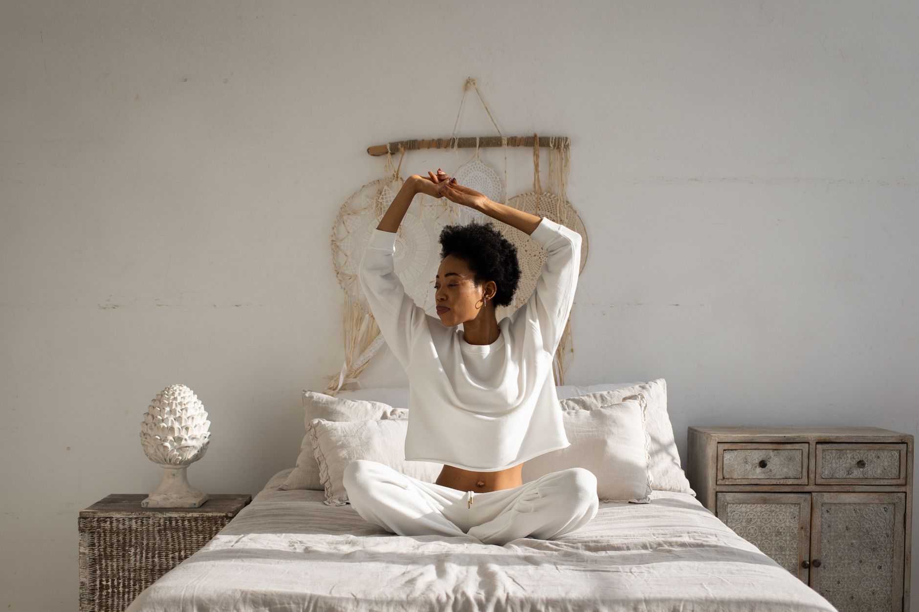 Femme assise en tailleur dans sa chambre