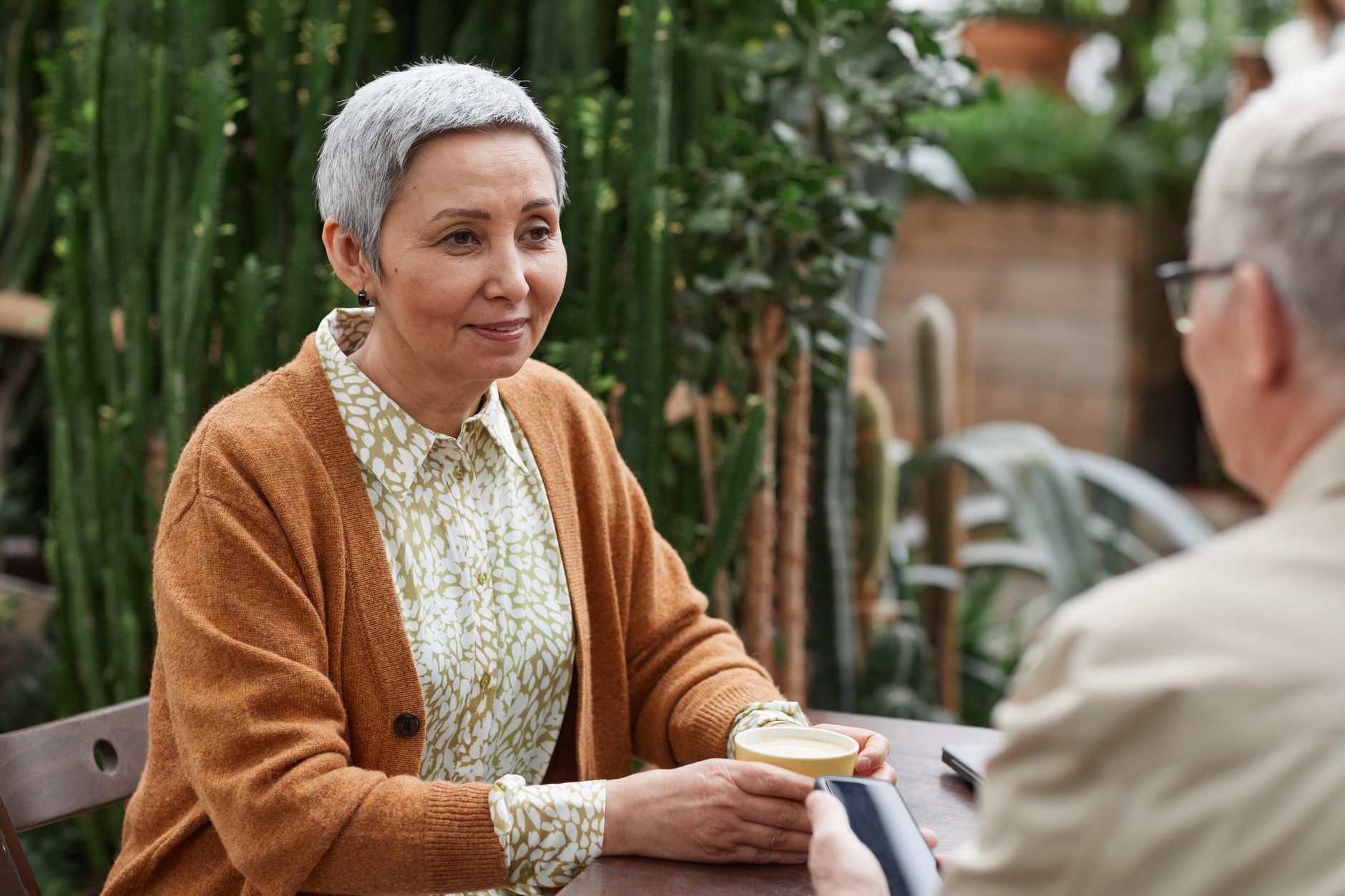 Couple de seniors qui prend un café dans un jardin