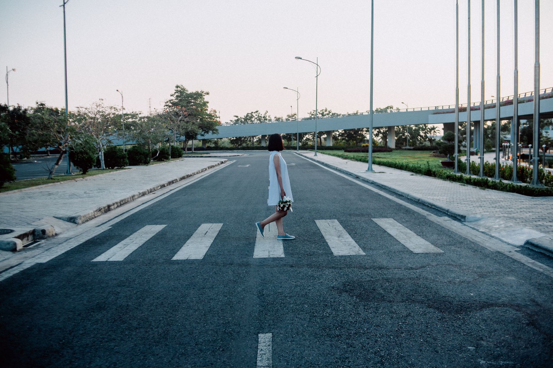 Femme traversant une rue de ville au coucher du soleil