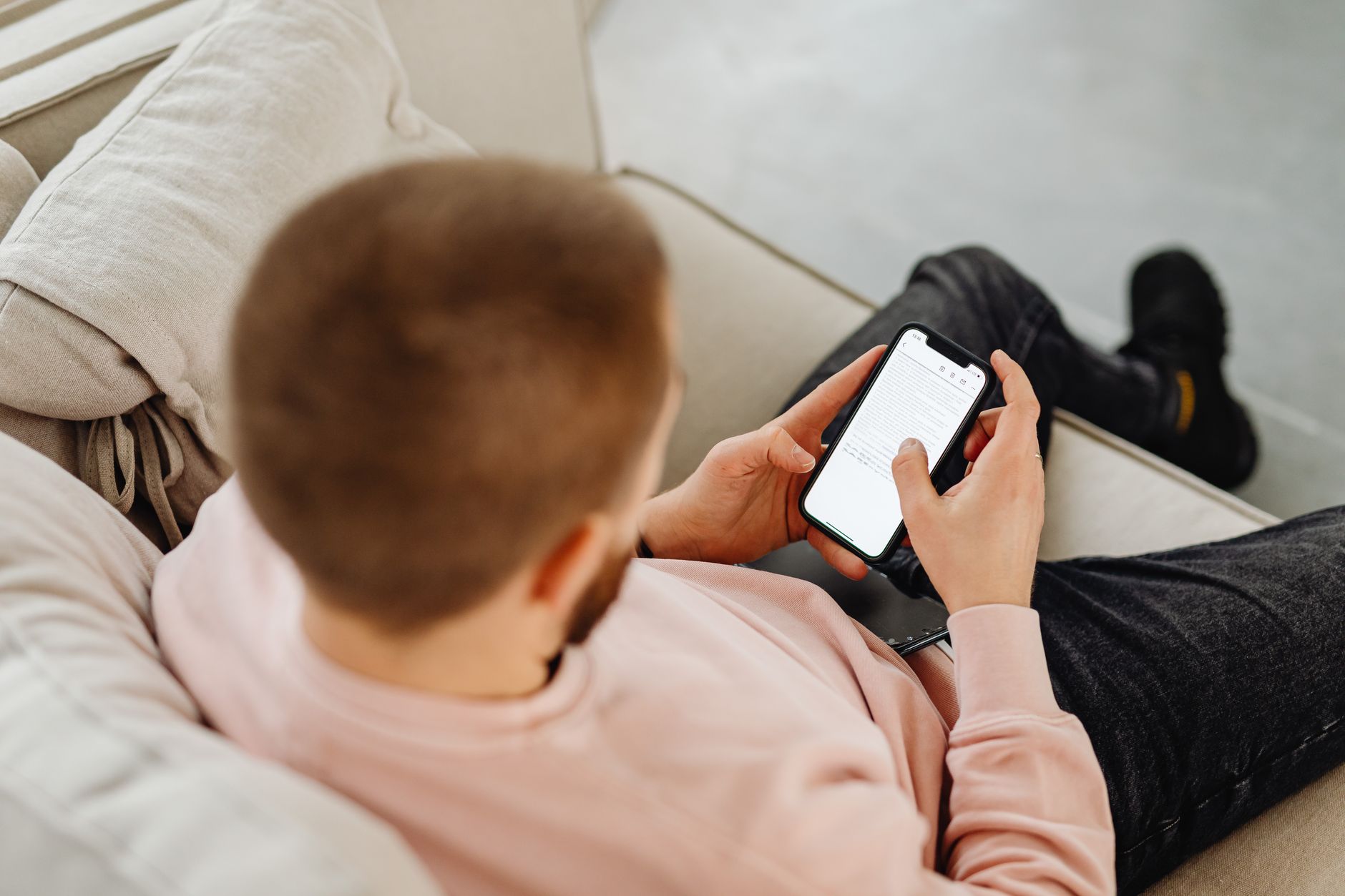 Homme absorbé par son téléphone sur un canapé