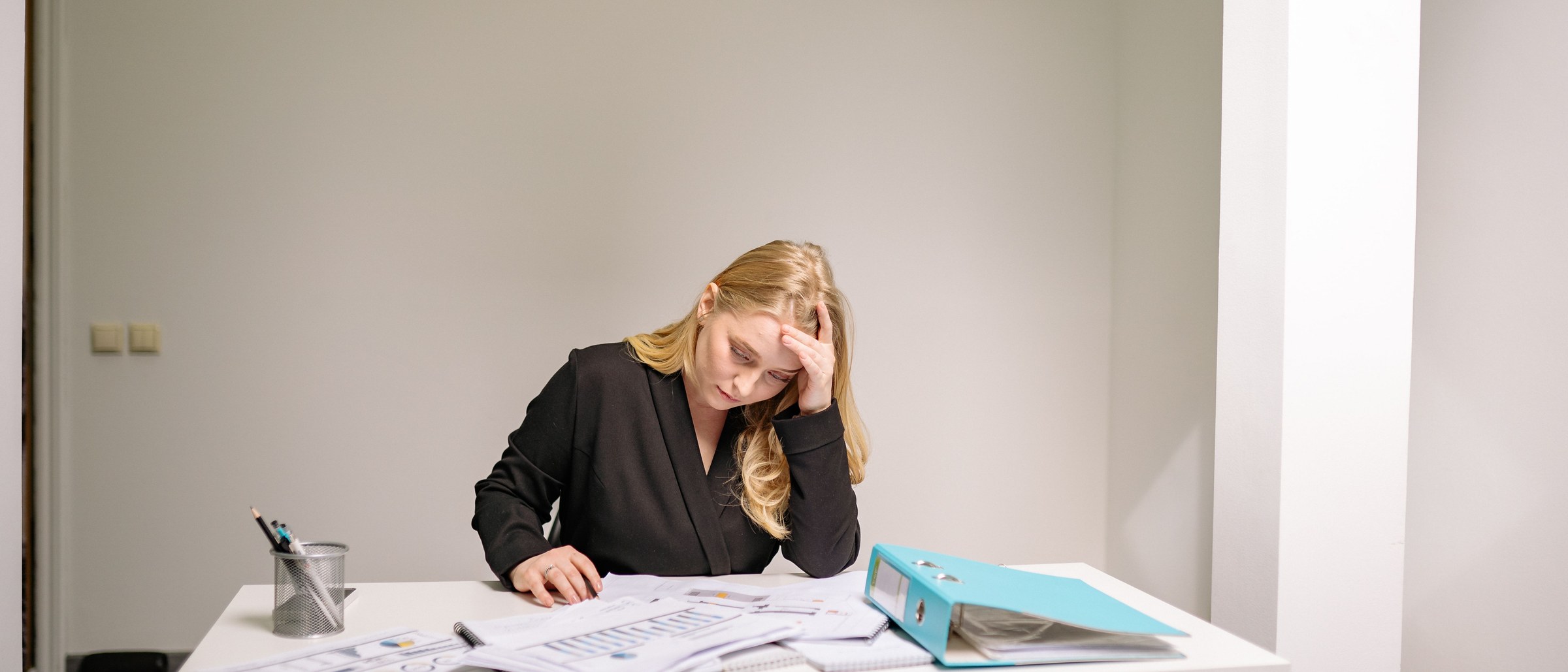 Femme stressée à son bureau, tête posée sur la main