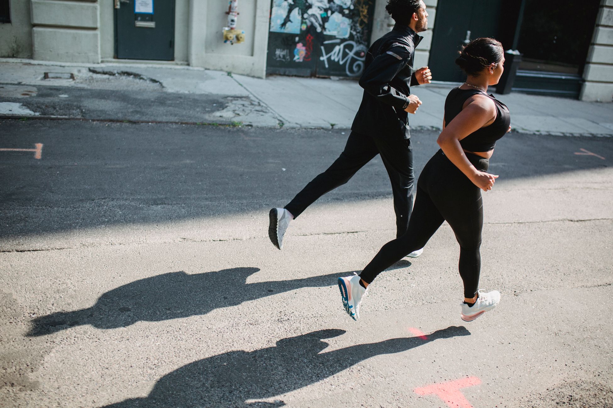 Deux joggeurs en tenue de sport dans une rue